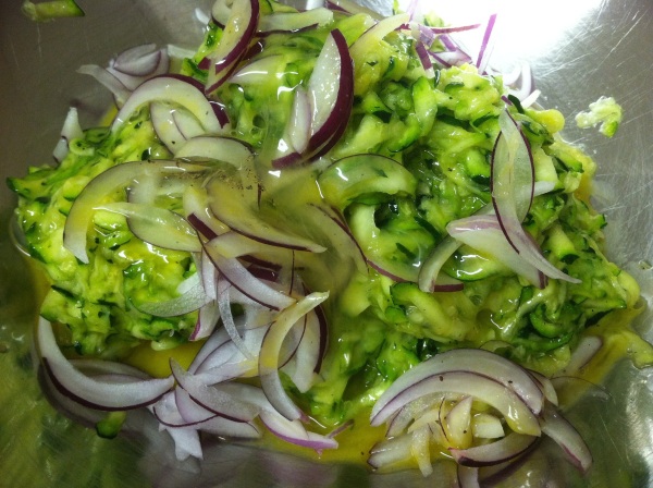 Add sliced onion and minced garlic to the squeezed zucchini. Mix well. Add beaten eggs.